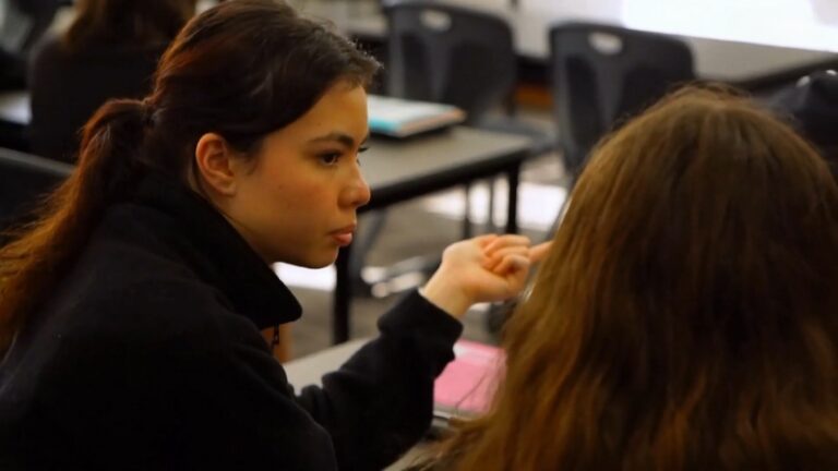 A Student Engages in A Discussion with A Peer During a Classroom Activity, Addressing Disruptive Behavior Constructively