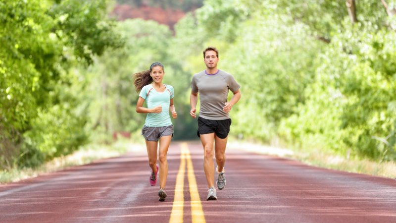 Man and woman run on a road, showing how exercise boosts energy for learning a new language