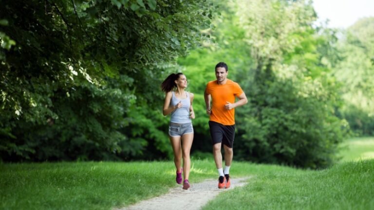A man and woman jog outdoors, showing how exercise can support focus and memory when learning a new language