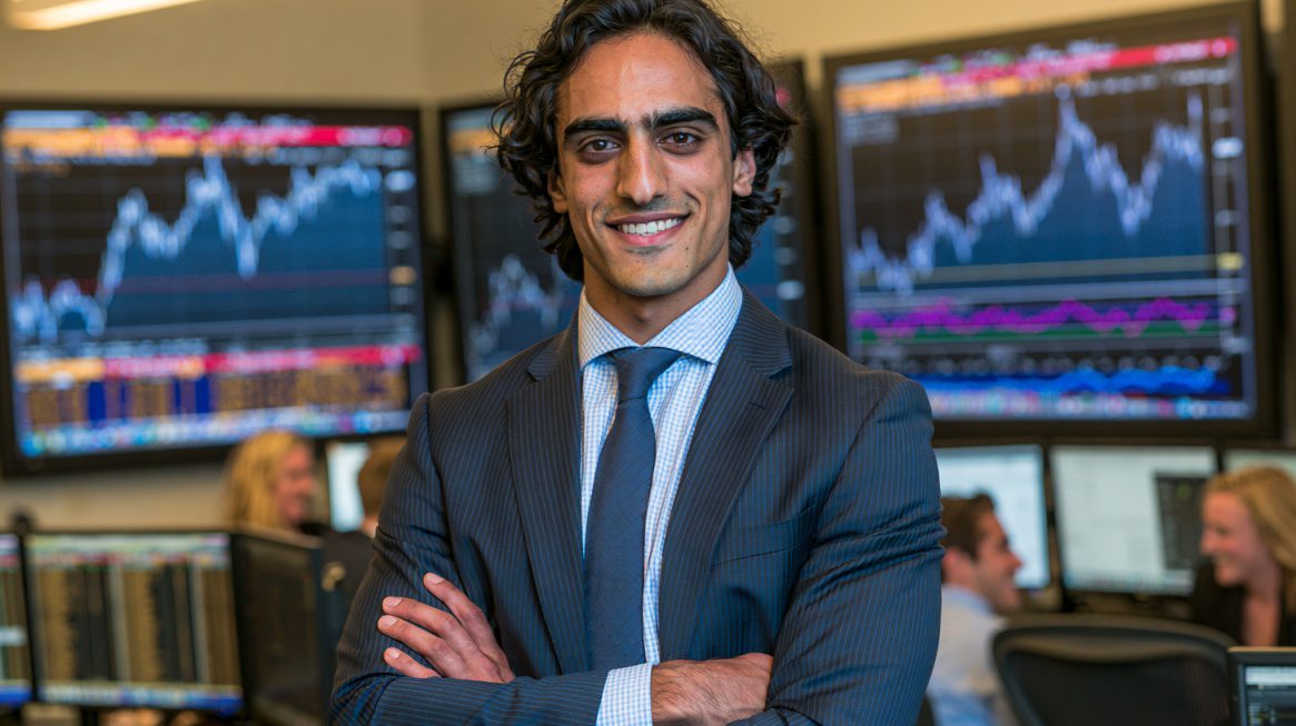 Young financial analyst standing in front of stock market charts.